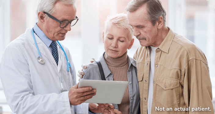Doctor reviewing data with two adults